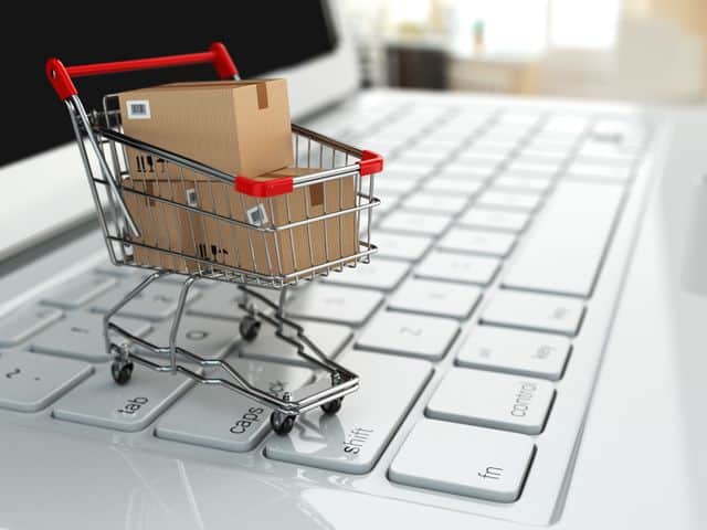 e commerce. shopping cart with cardboard boxes on laptop.